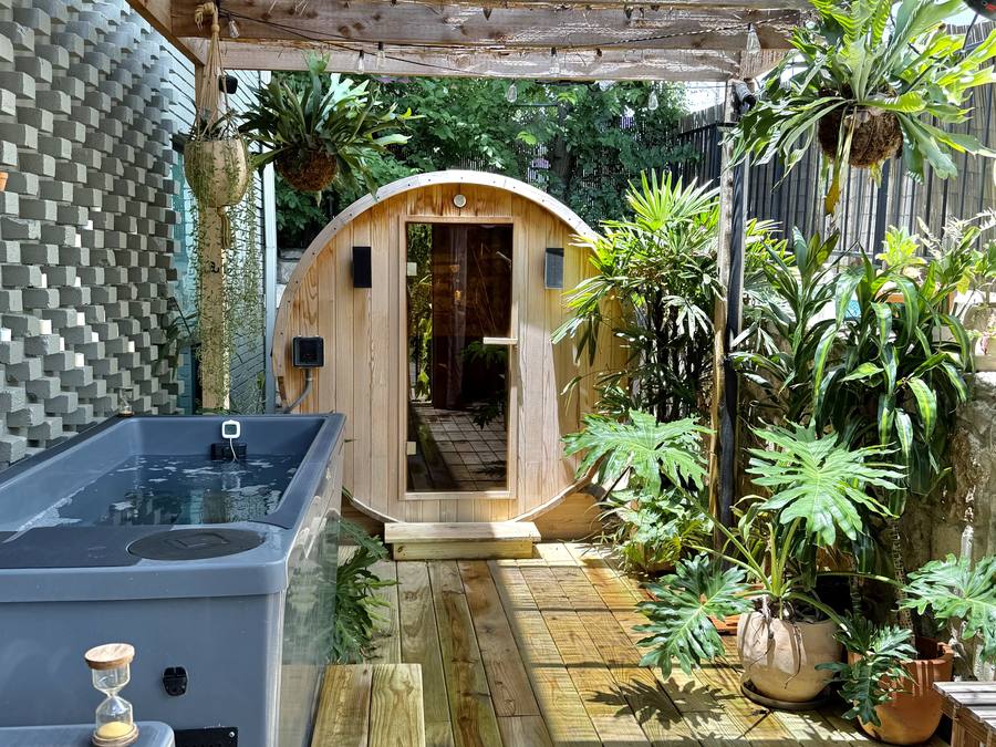 The communal garden at Cøntrast — traditional wood sauna and cold plunges surrounded by planting
